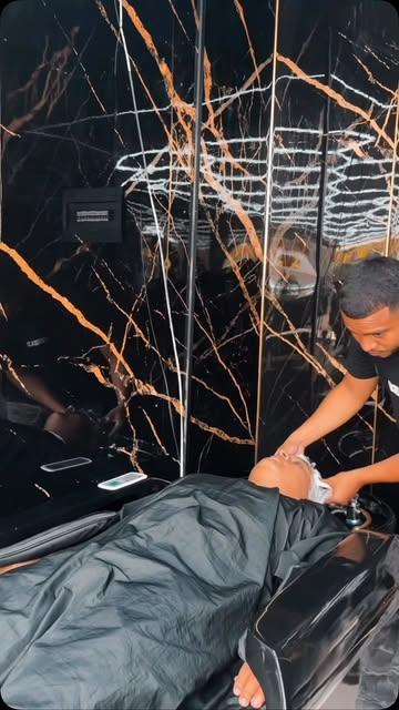Lavado de cabello en la cama de masaje, bajo un techo de luces y mármol con vetas doradas