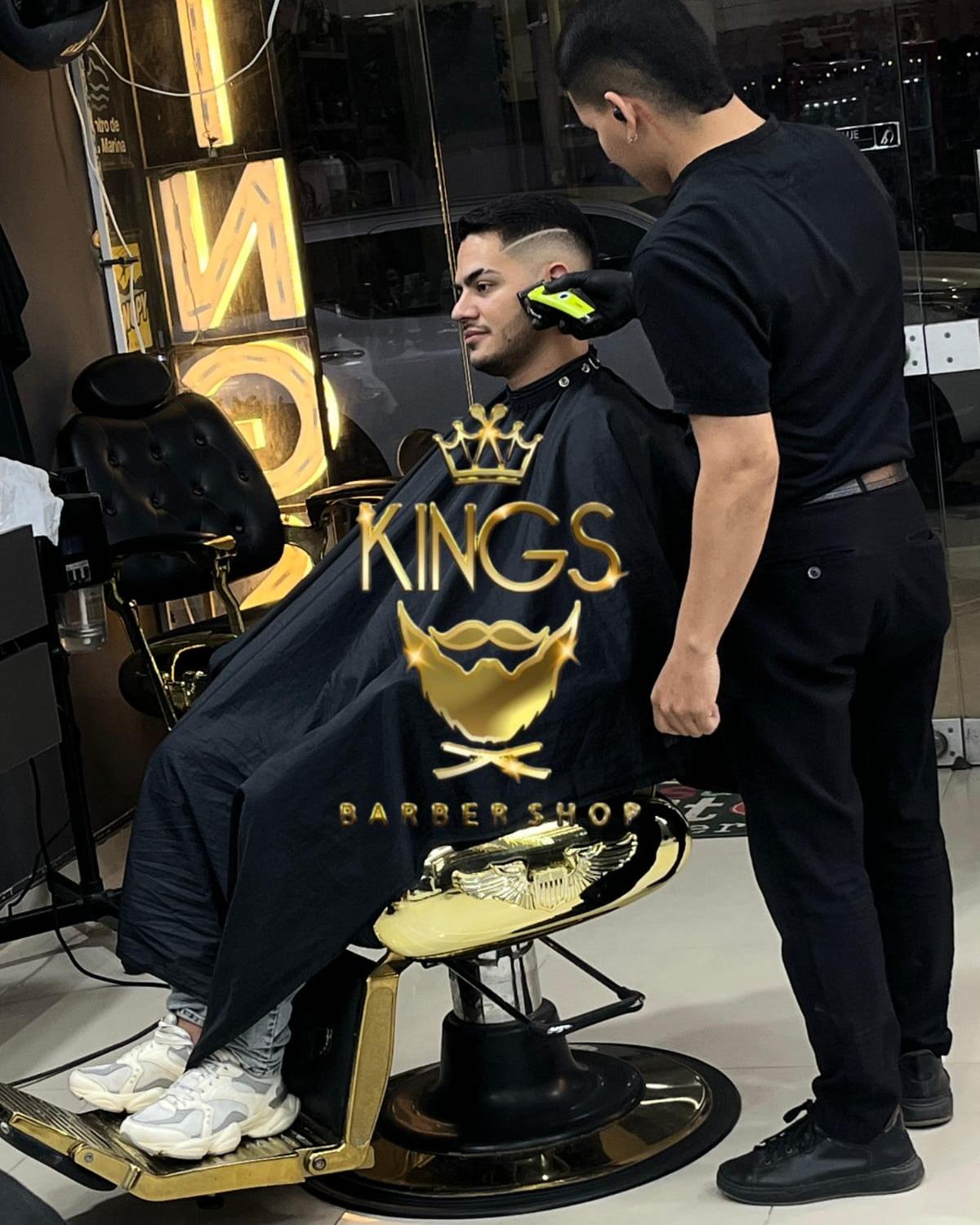 Cliente en silla dorada mientras el barbero termina su corte