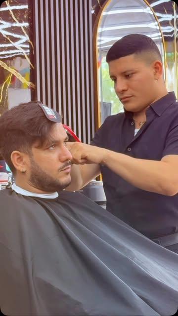 Barbero de Kings peinando y cortando a un cliente